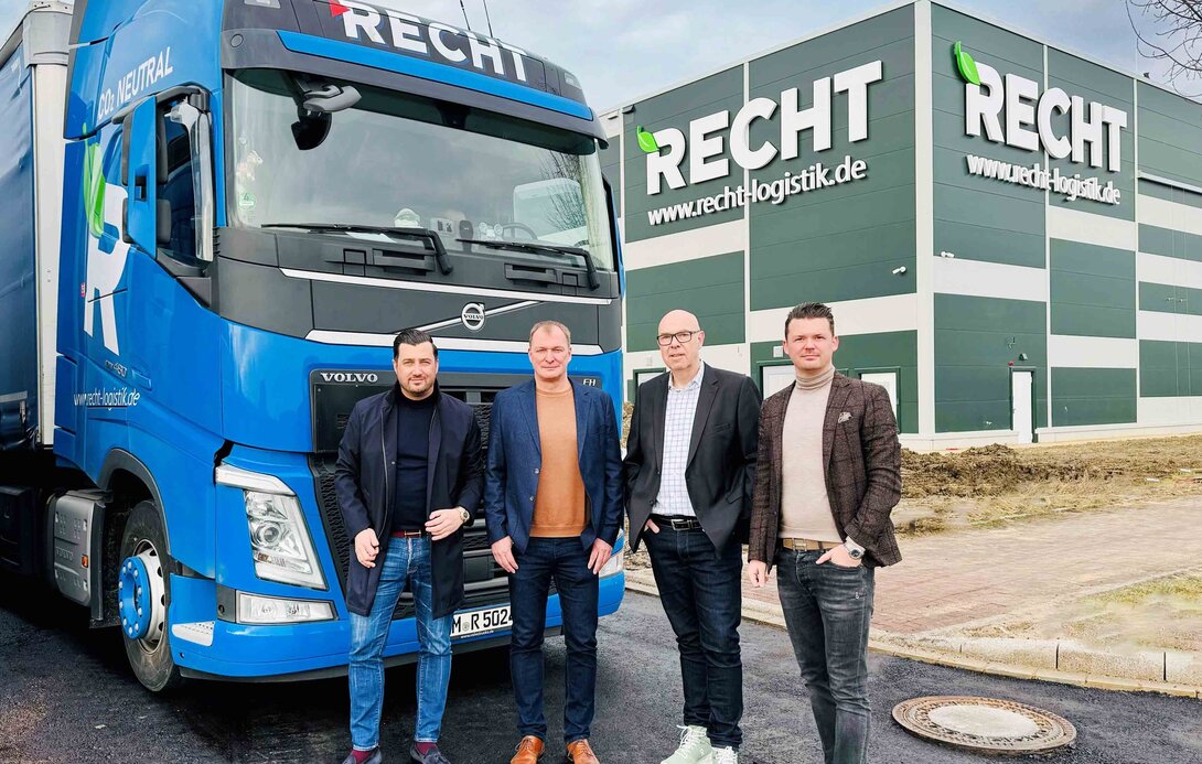 Gruppenbild vor einem Lkw und dem neuen Gebäude der RECHT Logistik Gruppe.